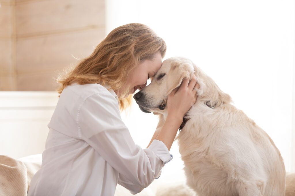 mulher a abraçar o focinho de um cão branco